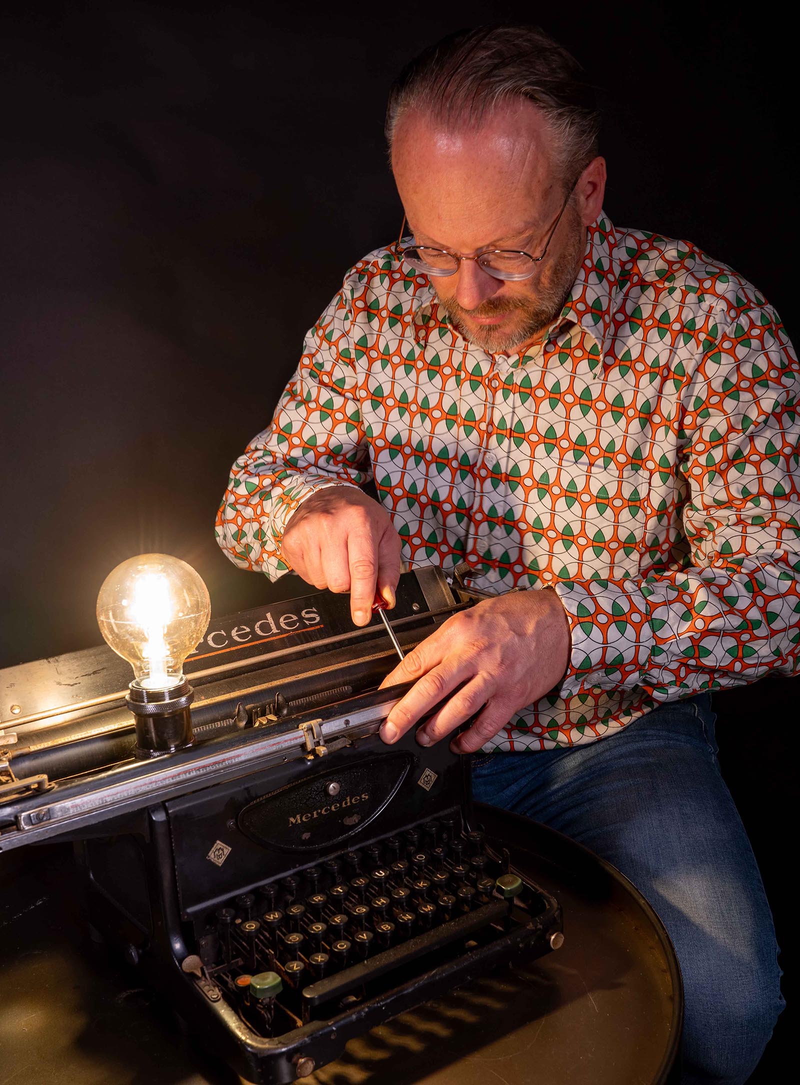 Muzieklampen Maurice Urlings met typemachine aan het werk